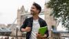 A guy smiling in London with Tower Bridge behind him